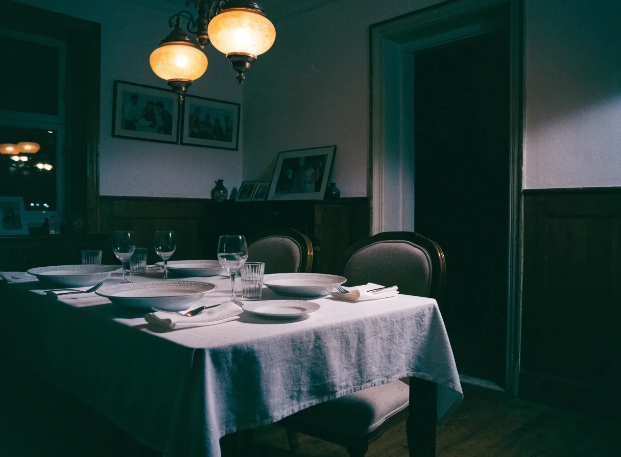 Comedor familiar de una casa mayor con la mesa puesta y sillas vacías